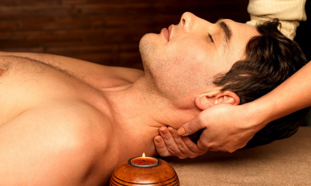 Masseur doing neck massage on man in the spa salon.